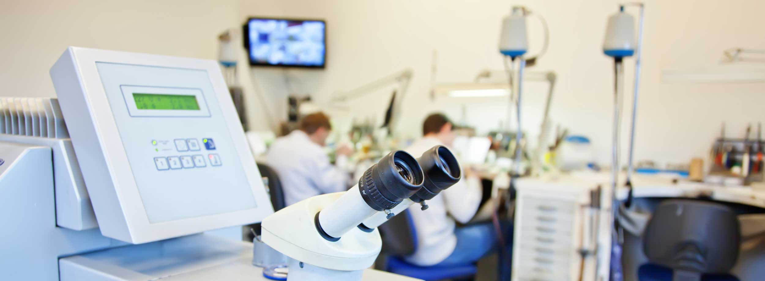 Two people sitting in a jeweler workshop.