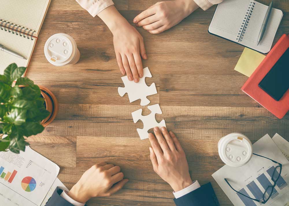 Conceptual image about business planning - two people putting puzzle pieces together