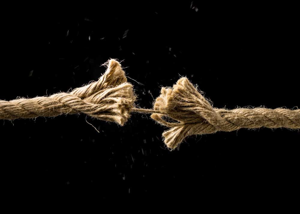Image of a frayed rope holding on by one strand