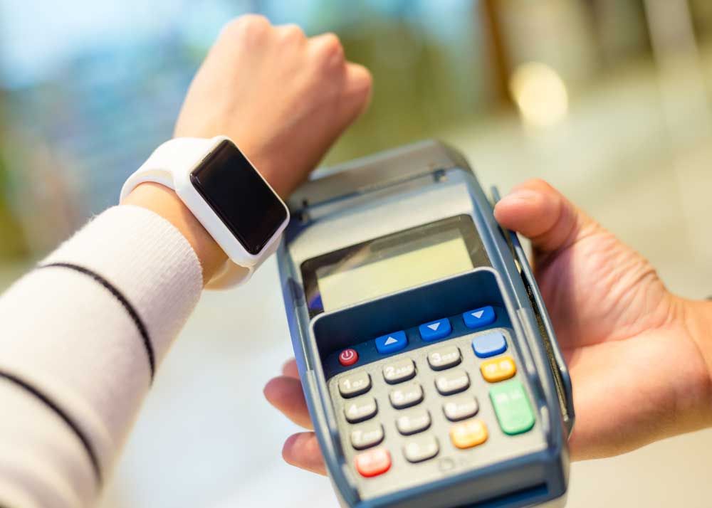 Woman using a smart-watch to pay for a retail purchase